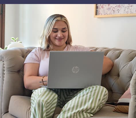 person sitting in a couch using HP laptop