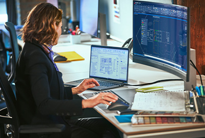 a lady is working with a workstation in an office