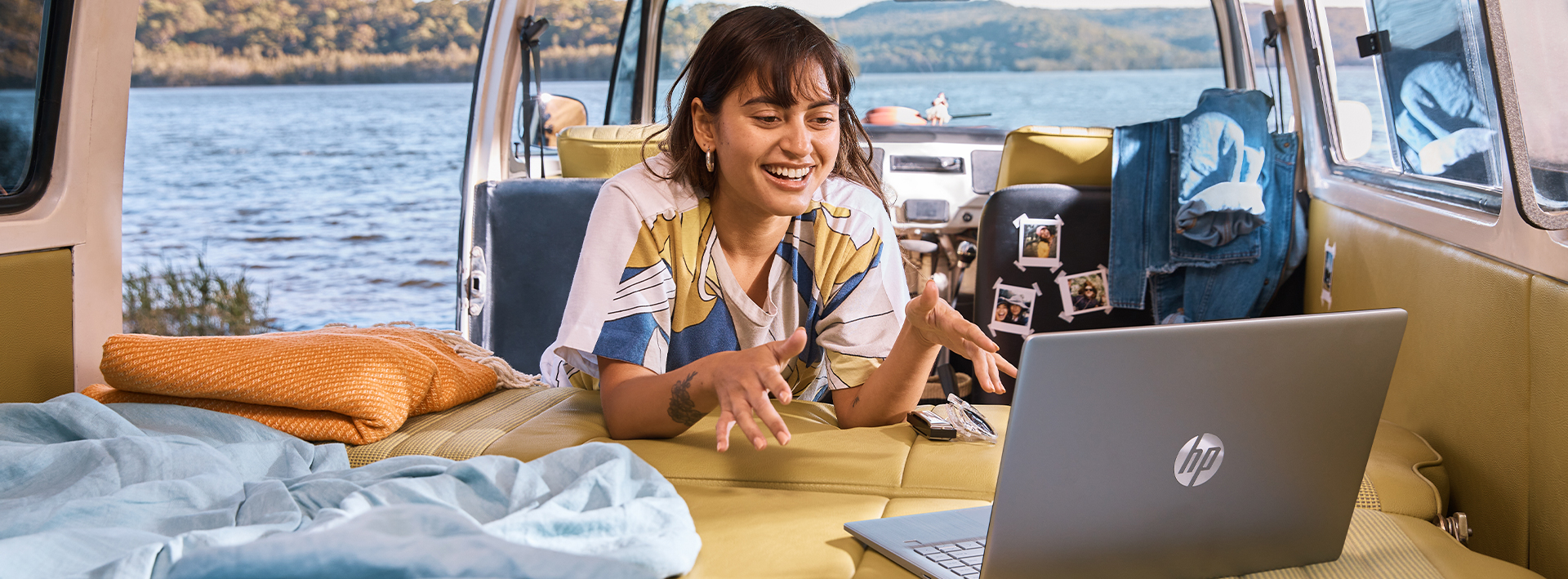 woman online shopping using HP laptop in a van near the lake